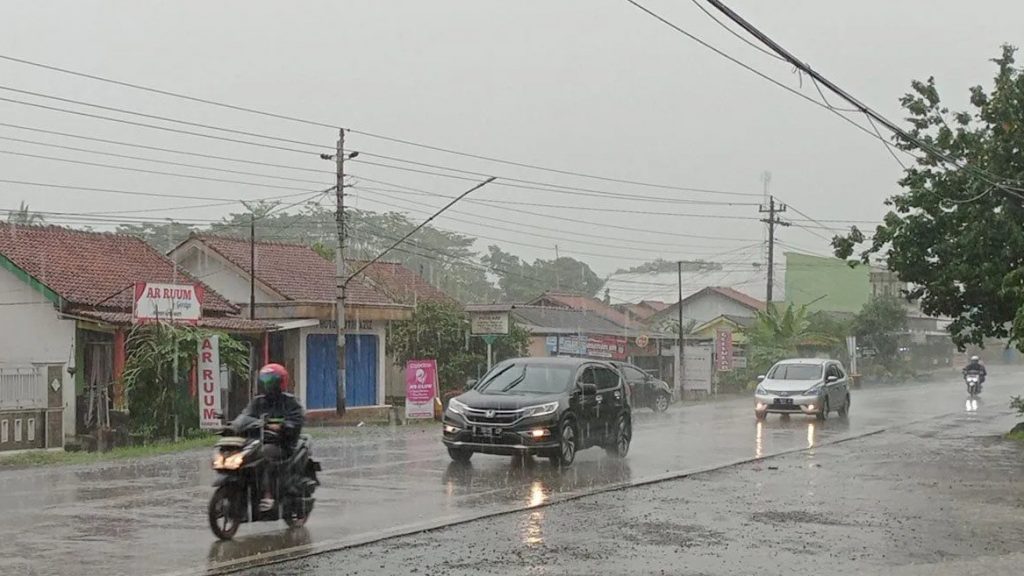 Pengendara sepeda motor menerobos hujan lebat yang mengguyur ruas Jalan Raya Cilacap-Yogyakarta, Desa Kalisabuk, Kecamatan Kesugihan, Kabupaten Cilacap, Jumat (1/12/2023) pagi.