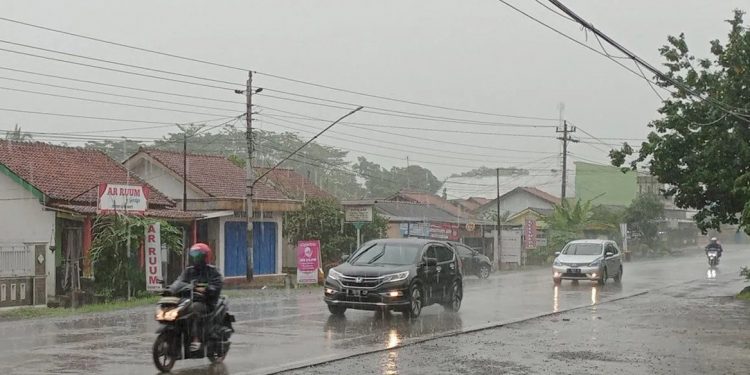 Pengendara sepeda motor menerobos hujan lebat yang mengguyur ruas Jalan Raya Cilacap-Yogyakarta, Desa Kalisabuk, Kecamatan Kesugihan, Kabupaten Cilacap, Jumat (1/12/2023) pagi.