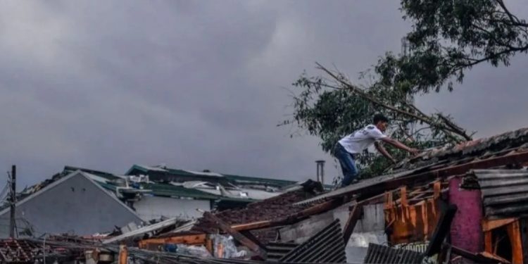 Warga memeriksa atap rumanya yang rusak pascaputing beliung yang terjadi di Rancaekek, Kabupaten Bandung, Jawa Barat, Rabu (21/2/2024). (Raisan Al Farisi)