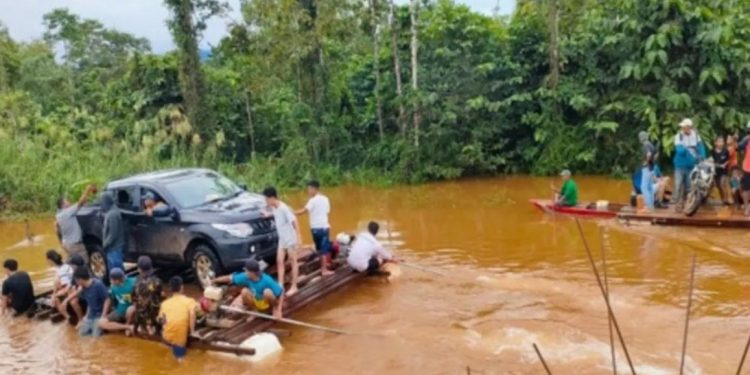 Warga korban banjir bergotong royong menyeberangkan kendaraan mereka menggunakan rakit anyaman dari bambu dan kayu di Konawe Utara, Sulawesi Tenggara, Jumat (10/5/2024). (BNPB)